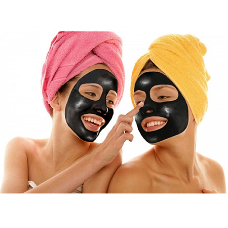 Två kvinnor som använder rengörande svart ansiktsmask.