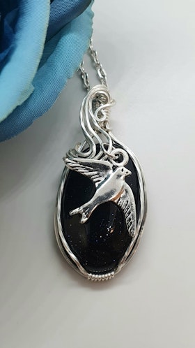 Halsband Swirly Swallow i 925 sterlingsilver med blå guldsten
