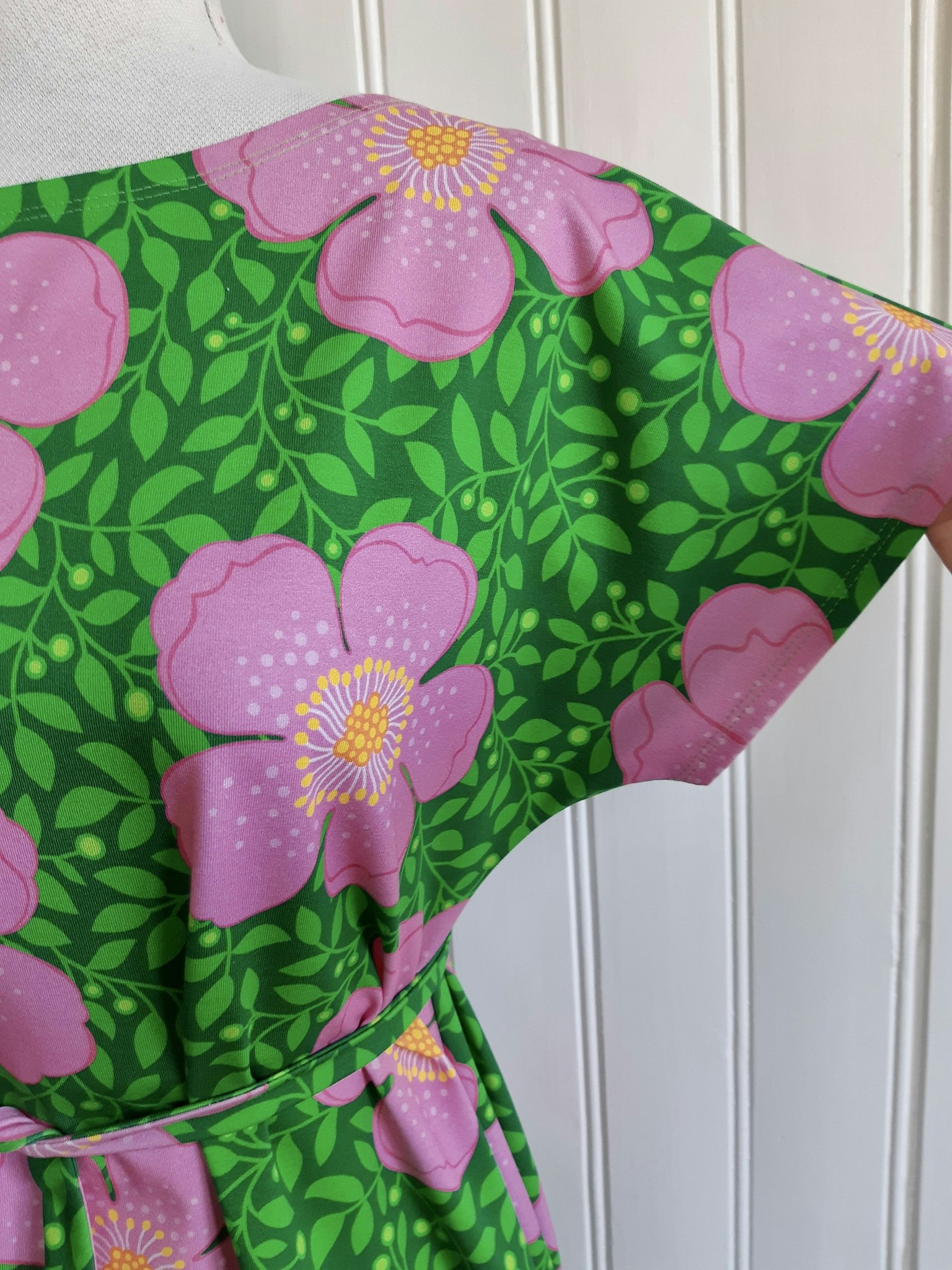 Rosa blommor och gröna blad