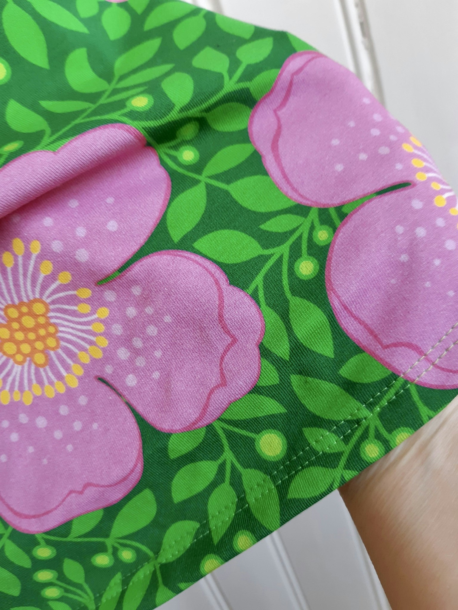 Rosa blommor och gröna blad