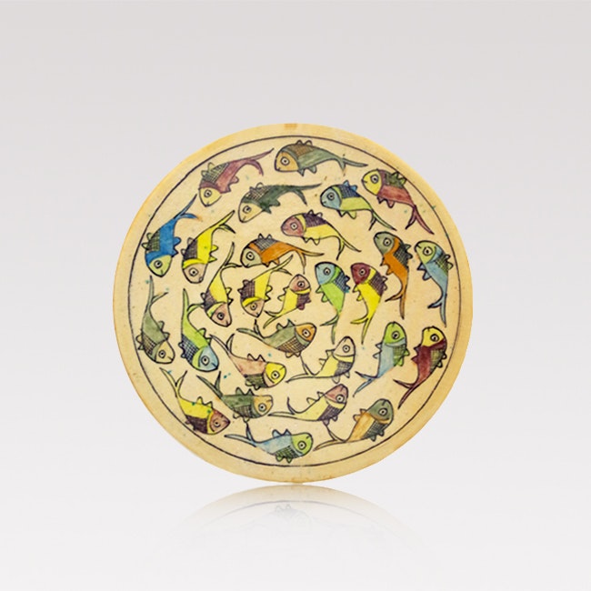 A large, round handmade Iranian serving plate with hand painted colourful fish pattern on beige.