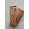 A small, handmade board game made from teak. Rectangular, 24x10 cm with lid and black and white wooden pegs.