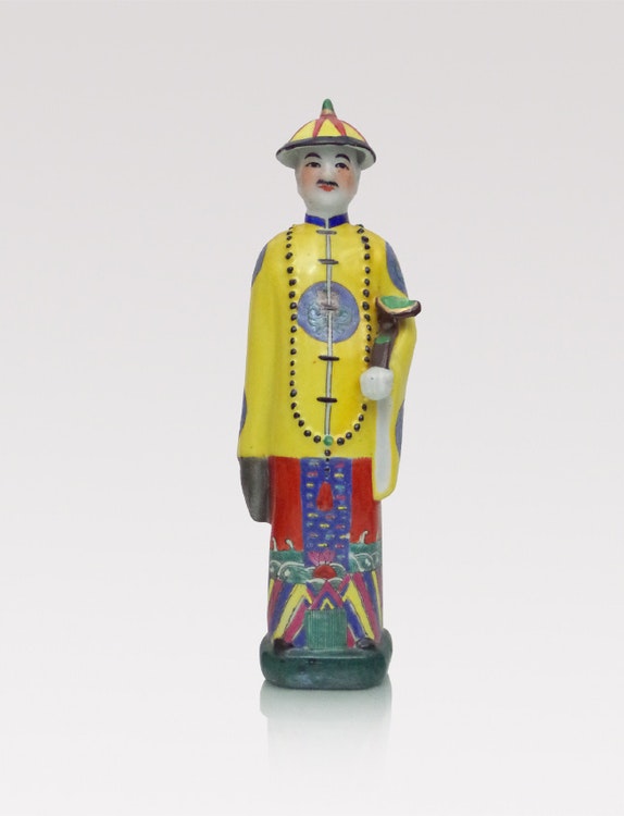 Handmålad kinesisk porslinsfigur med gul jacka och hatt. Framsidan har  vackert detaljerad målning av ansikte och kläder.