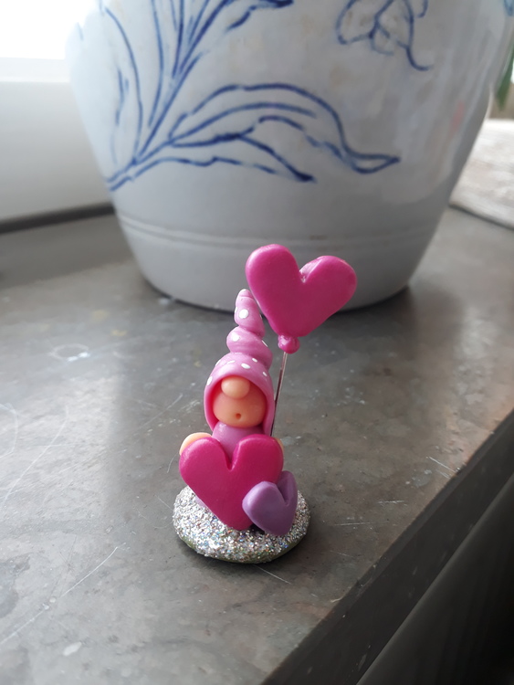 Fristående rosa nisse med hjärtan och ballong