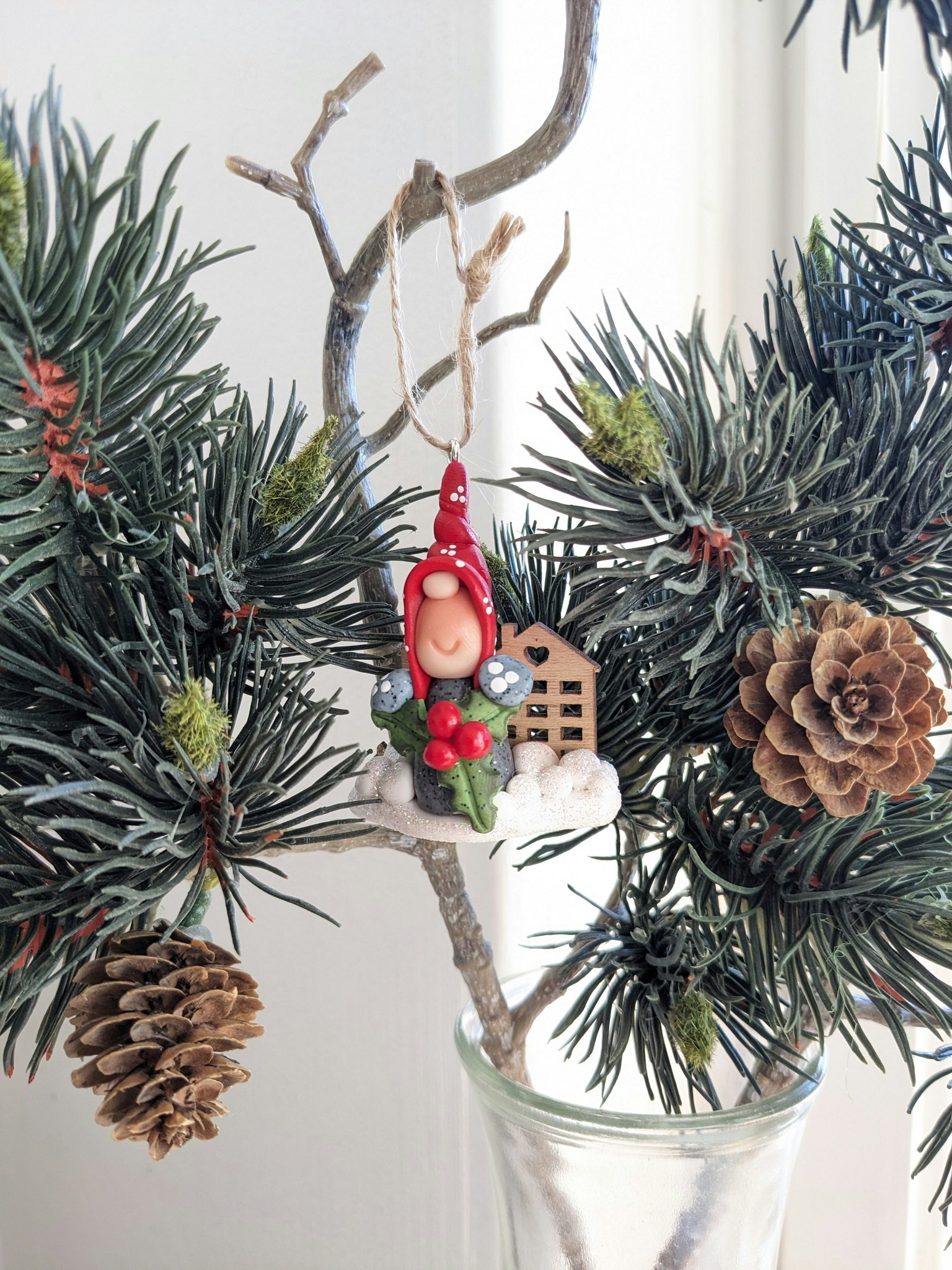Julgranshänge- Nisse med julbär och söta trähus i bakgrunden