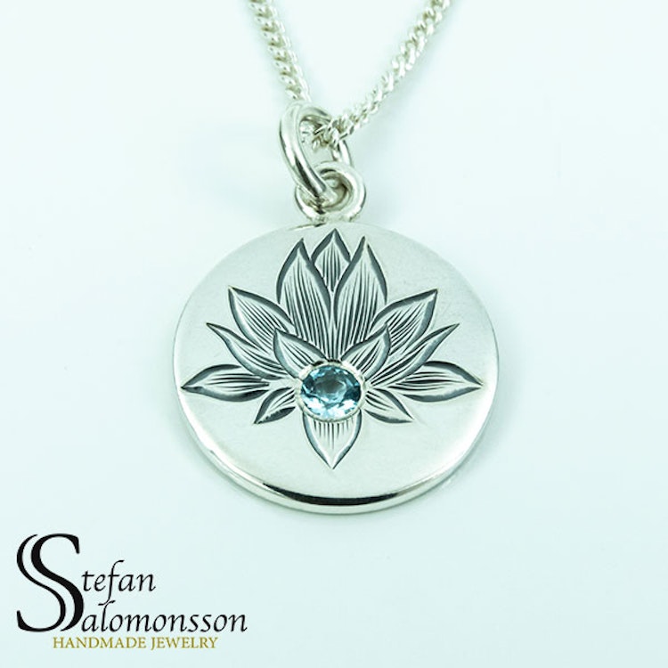 Hand-engraved lotus pendent in silver with a topaz