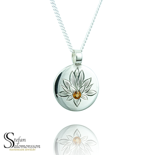 Hand-engraved lotus pendent in silver with a hessonite garnet