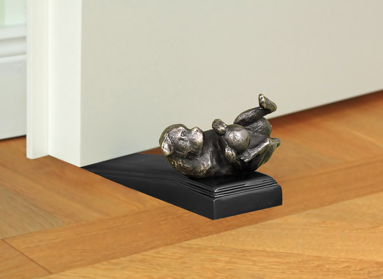Door stop with dog playing with ball in antique brass design