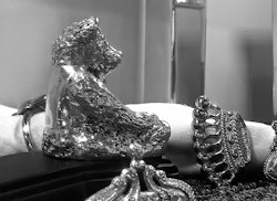 Door stop with teddy bear dressed for party in silver plating