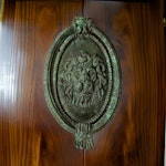 Door knocker with lion mascaron in bronze