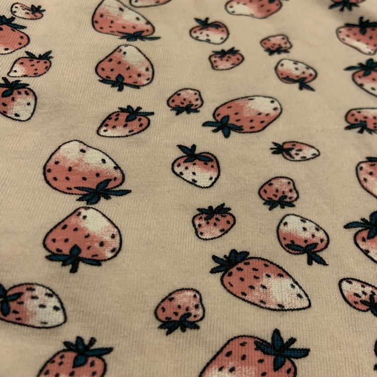 Ljusrosa kortärmad body med mönster av jordgubbar från Name It stl 62