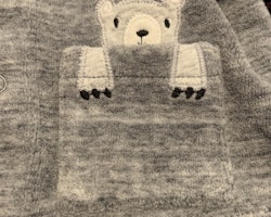 Grå tröja med knäppning, huva med öron och en björn applikation vid fickan från HM stl 56
