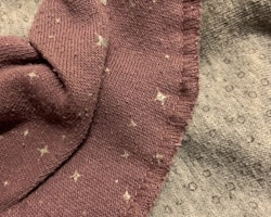 Två haklappar i lila och grått med mönster av bubblor och stjärnor från Pippi