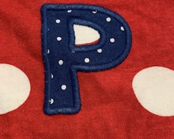 Röd t-shirt med vita prickar och ett blått A med små vita prickar från PoP stl 68