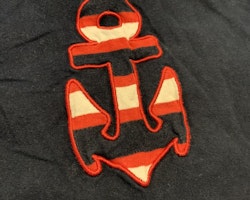 Mörkblå t-shirt med detaljer såsom ett ankare i rött och vitt från Lingon & Blåbär stl 70
