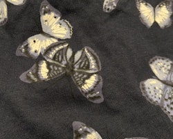 Mörkblå klänning med volanger och fjärilar i vitt och olika blå nyanser från HM stl 68