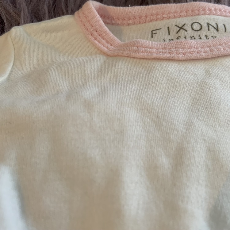 Vit body med rosa kantband och rosa och vit randig ärmlös jumpsuit med en giraffapplikation från Fixoni stl 50