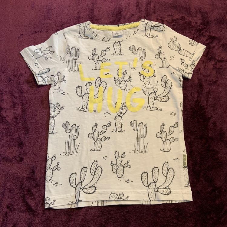 Vit t-shirt med svarta kaktusar, bröstficka och gult texttryck från Lindex stl 98/104