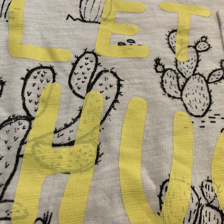 Vit t-shirt med svarta kaktusar, bröstficka och gult texttryck från Lindex stl 98/104
