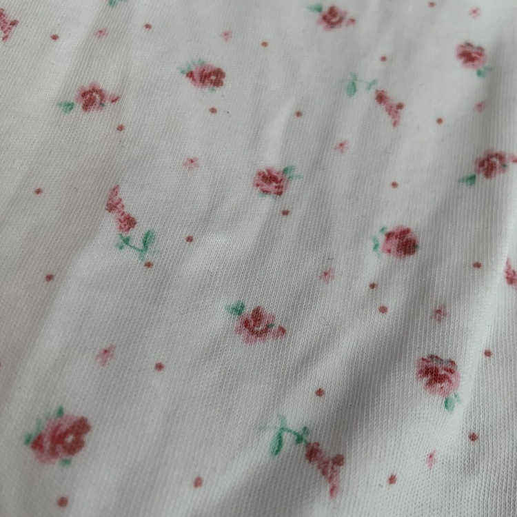 En rosa och en vit kortärmad body med smått blommönster från NeXT stl 62/68