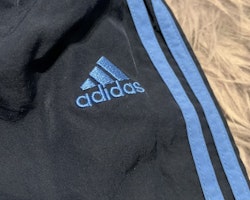 Mörkblå träningsbyxor med blå detaljer från Adidas stl 74