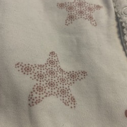 Vit pyjamas med gammelrosa stjärnor med olika mönster från Newbie stl 50