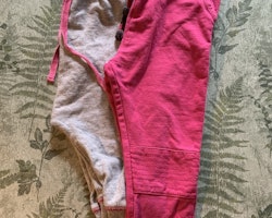 Ett par gråmelerade mjukisbyxor med rosa detaljer från Kaxs och ett par rosa byxor från Åhléns stl 86