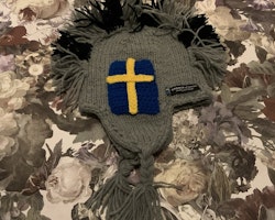 Grå och svart stickad mössa med en mohawk av garn och virkade svenska flaggor från Lundmyr of Sweden stl 0-6 mån