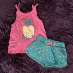 Set med rosa linne dekorerat med bl.a en ananas och ett par gröna shorts med rosa och gula prickar från Primark stl 80