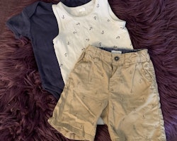 3 delat paket med en mörkblå kortärmad body, en vit linnesbody och ett par beigea shorts, båda med mörkblå ankare stl 74