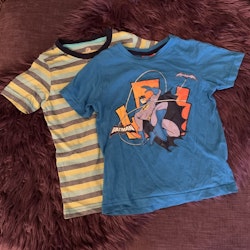 En flerfärgad randig t-shirt och en blå med Batmantryck stl 98/104