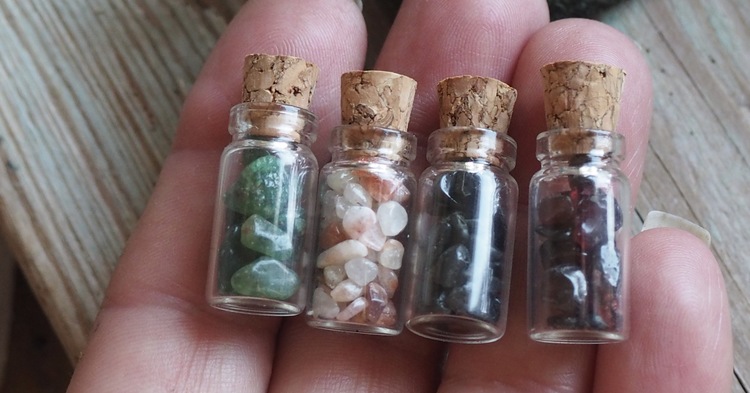 Små flaskor med trumlade stenar