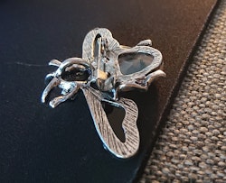 Brosch/berlock i form av en fluga med blå Guldsten och antikt silverfärgade detaljer