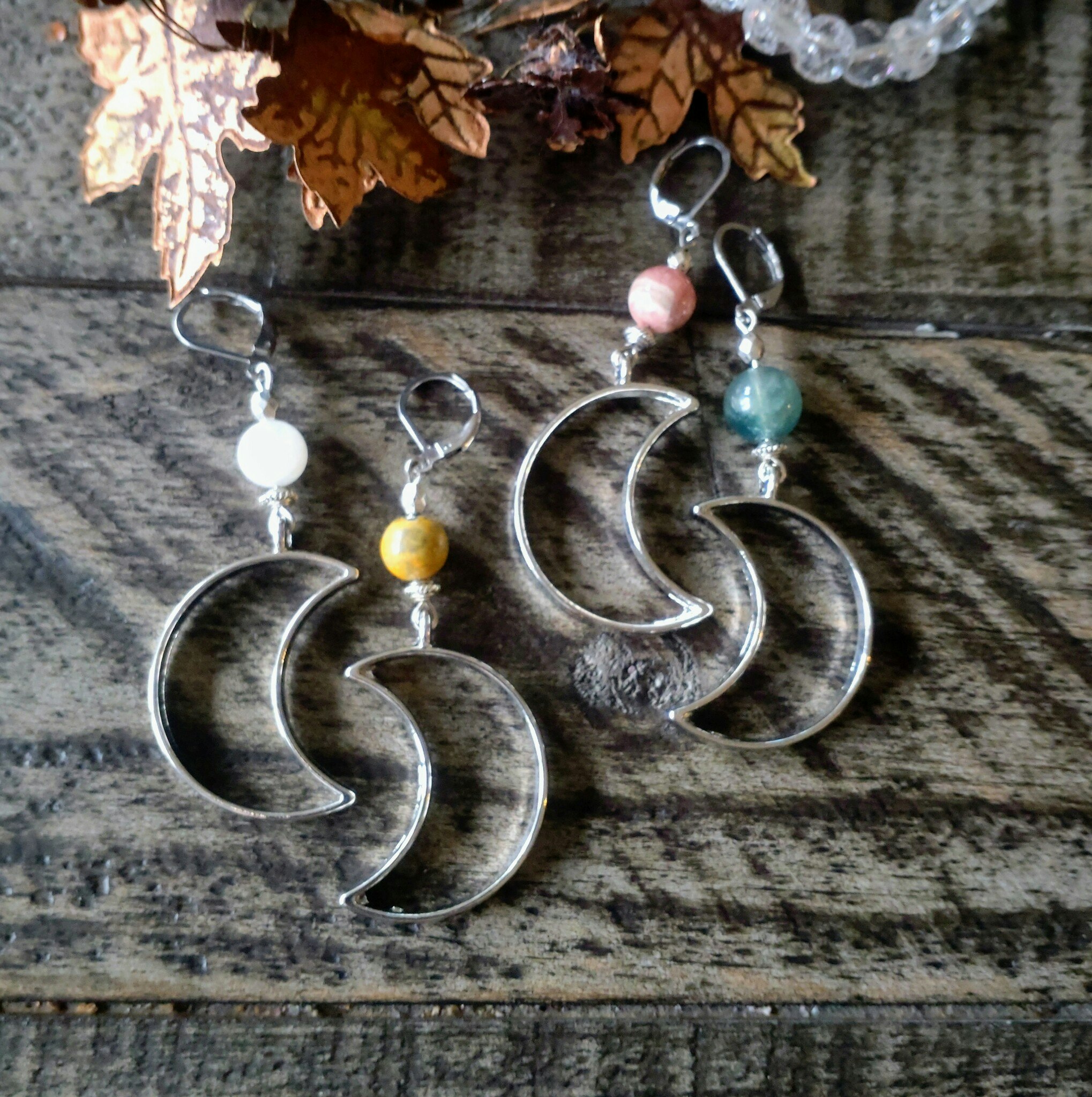 Silverfärgade örhängen med månar och olika kristaller