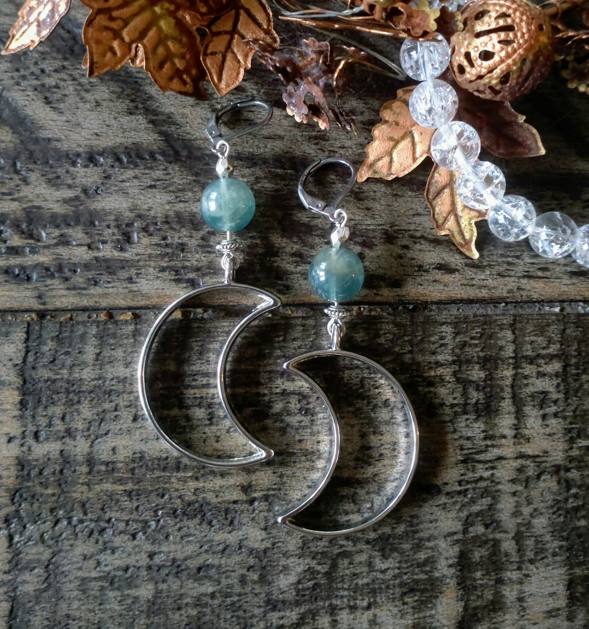 Silverfärgade örhängen med månar och olika kristaller
