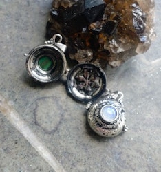 Antikt silverfärgade öppningsbara berlocker med olika kristaller i rund design