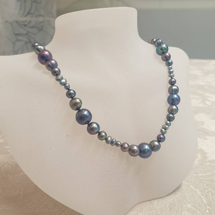 Halsband med blå pärlor i vågmönster