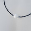 Halsband med svart spinell och vit agat slipad som golfboll