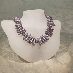 Halsband med lila pärlor i olika former och magnetlås i silver