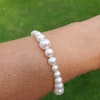 Armband med vita pärlor i olika storlekar