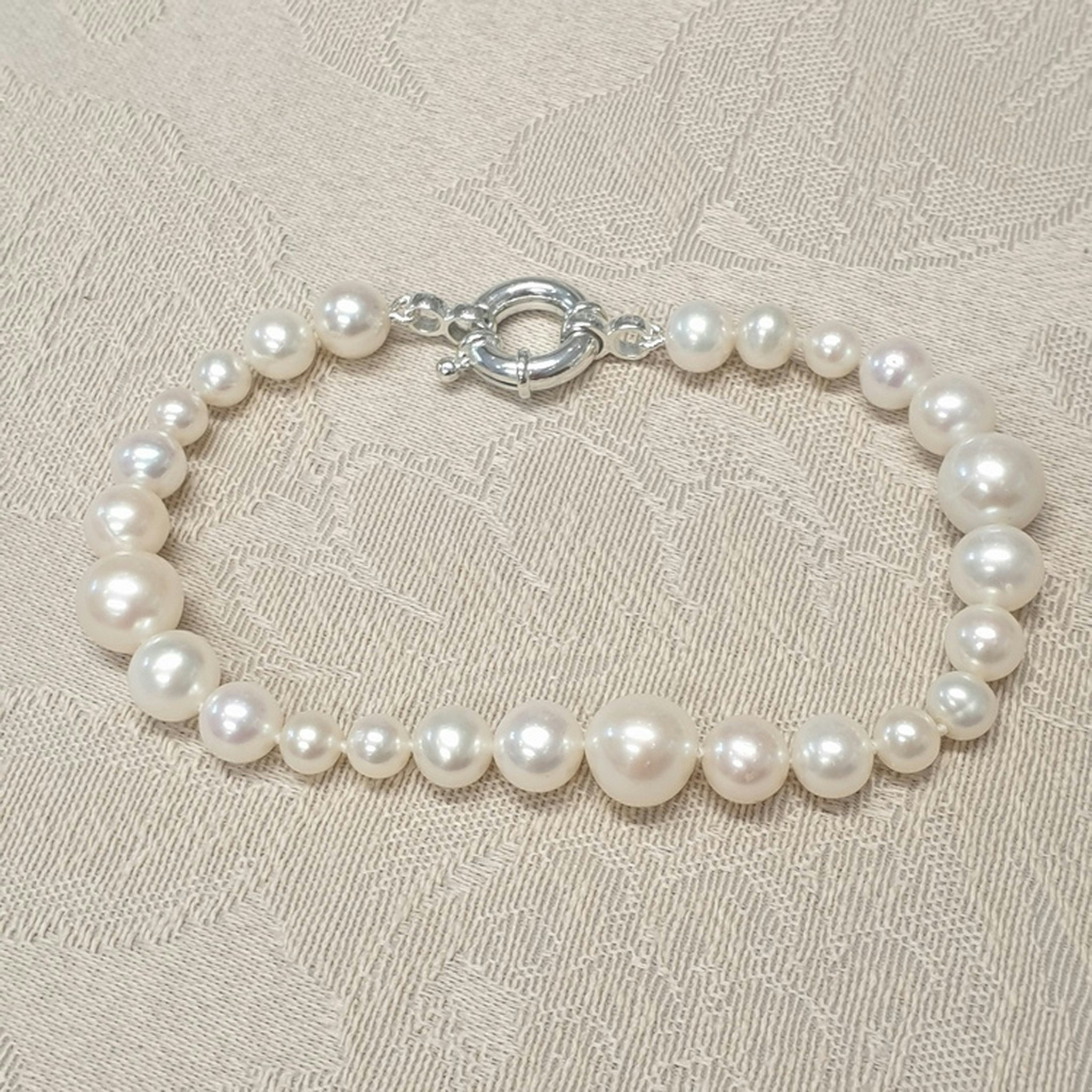 Armband med vita pärlor i olika storlekar