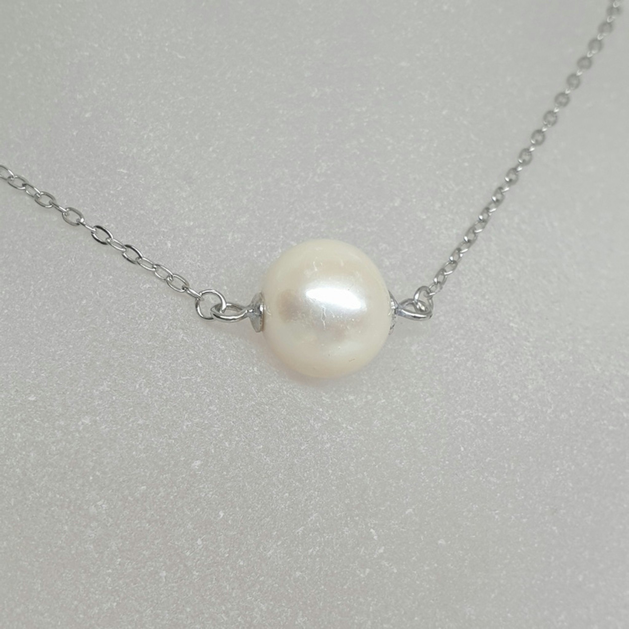 Halsband med vit rund pärlor och silverkedja