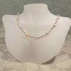 Halsband med pärlor i rosa-guld färgton