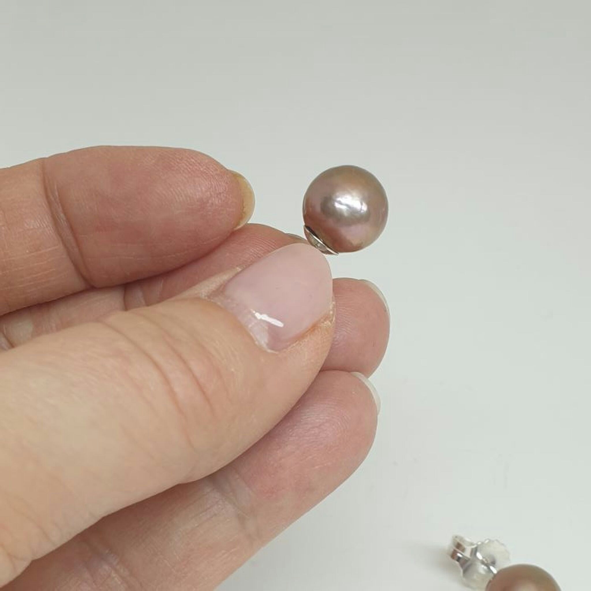 Magnifika stora, rosaskimrande pärlor på stift