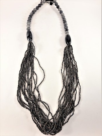 Långt halsband med stora och små pärlor i grått