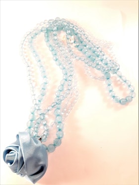 Halsband i blått med flerradiga plastpärlor och ros som dekoration