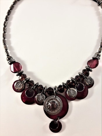 Detaljrikt halsband med många detaljer i lila och silverfärg
