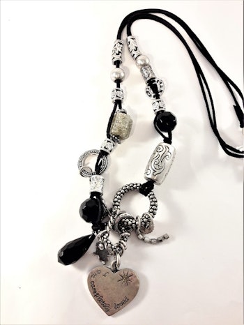 Halsband med silverfärgade och svarta detaljer såsom hjärta