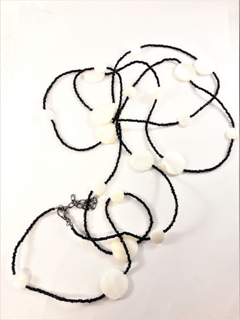 Långt halsband med svarta pärlor och vita snäckskal