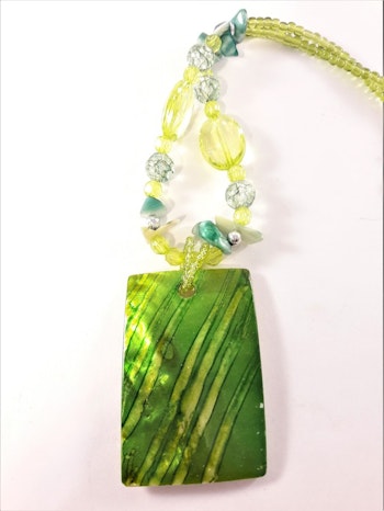 Halsband med gröna detaljer och snäckskal